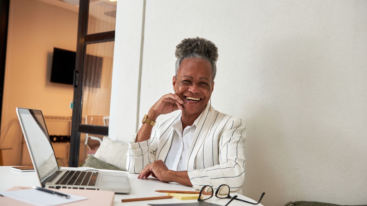 mulher madura, negra, senta na mesa de trabalho